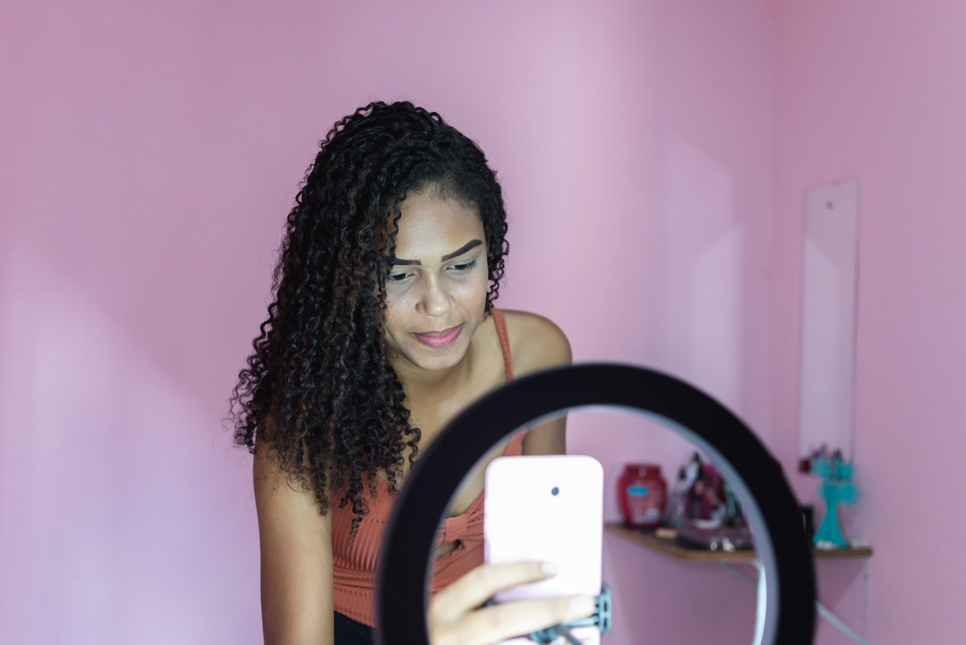 Black young woman filming herself dancing at home to share on social media
